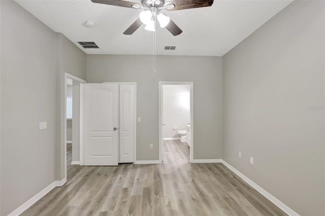unfurnished bedroom with ensuite bathroom, baseboards, visible vents, and light wood-type flooring