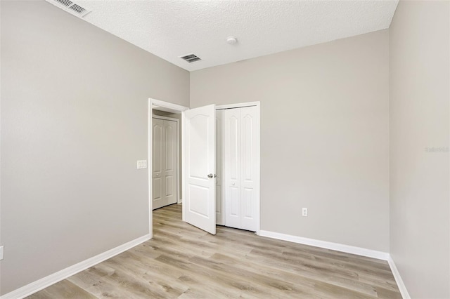 unfurnished bedroom featuring baseboards, visible vents, and light wood-style flooring