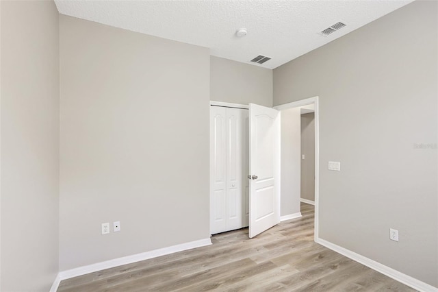 unfurnished bedroom featuring baseboards, visible vents, and light wood-type flooring