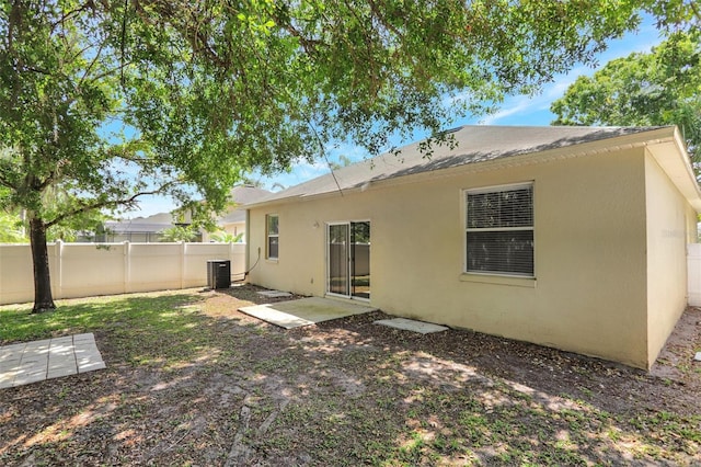 back of house with stucco siding, fence, and central AC