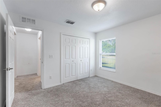 205 Lori Ct, Umatilla, FL 32784 - unfurnished bedroom with a closet, baseboards, carpet, and visible vents
