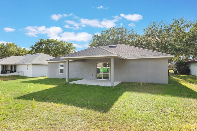 205 Lori Ct, Umatilla, FL 32784 - rear view of house featuring roof with shingles, a patio area, stucco siding, and a lawn