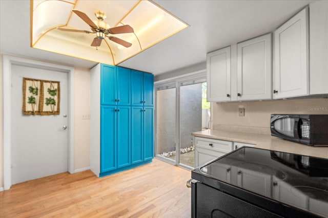 121 Teriwood St, Fern Park, FL 32730 - kitchen with blue cabinetry, light countertops, light wood-style floors, white cabinets, and black appliances