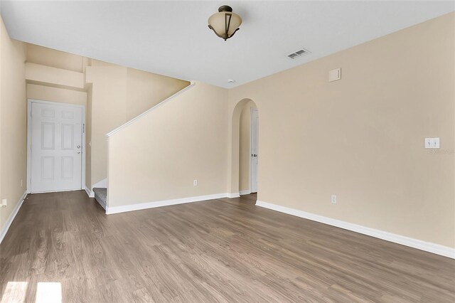 1556 Sherbourne St, Winter Garden, FL 34787 - unfurnished living room with stairway, baseboards, arched walkways, visible vents, and wood finished floors