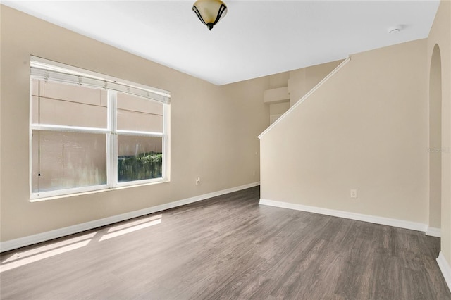 1556 Sherbourne St, Winter Garden, FL 34787 - empty room with arched walkways, baseboards, wood finished floors, and stairs