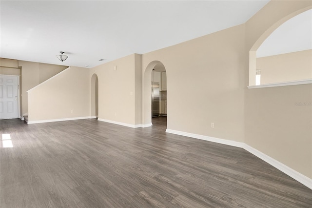 1556 Sherbourne St, Winter Garden, FL 34787 - unfurnished living room featuring dark wood-style flooring, arched walkways, and baseboards
