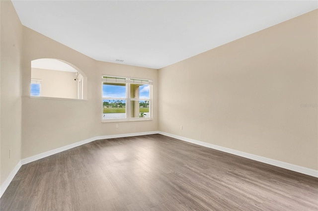 1556 Sherbourne St, Winter Garden, FL 34787 - empty room featuring dark wood-type flooring, visible vents, arched walkways, and baseboards