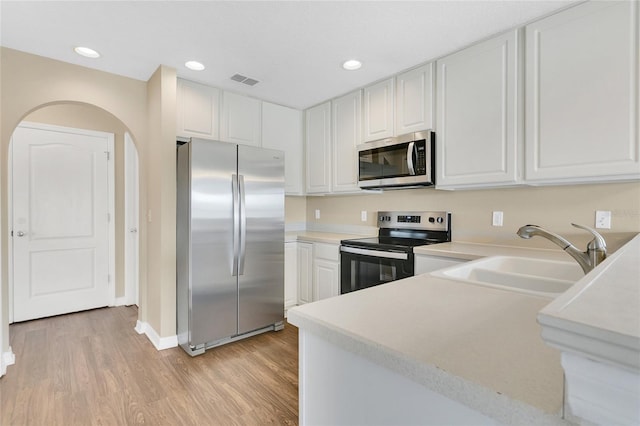 1556 Sherbourne St, Winter Garden, FL 34787 - kitchen with light countertops, visible vents, light wood finished floors, appliances with stainless steel finishes, and a sink