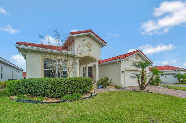 mediterranean / spanish house featuring a tile roof, stucco siding, and an attached garage