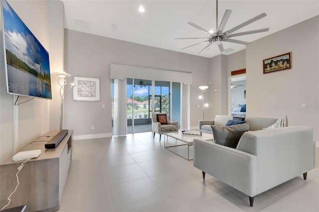 living area featuring light tile patterned floors, visible vents, baseboards, and ceiling fan