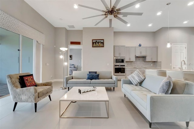 living room with ceiling fan, visible vents, and recessed lighting