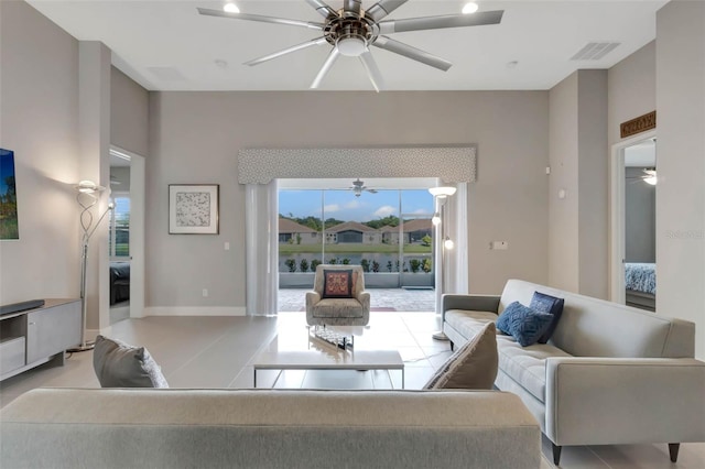 living area featuring visible vents, baseboards, and ceiling fan