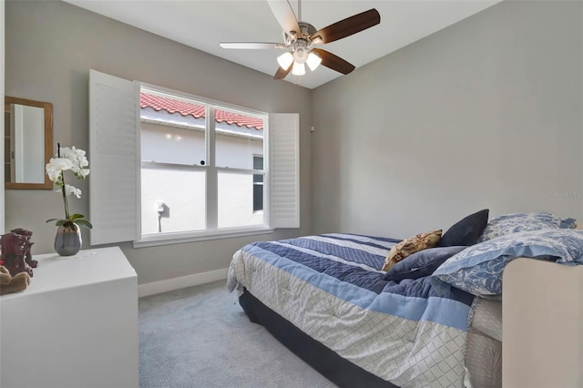 bedroom with baseboards, ceiling fan, and light carpet