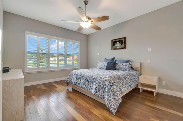 bedroom with baseboards, wood finished floors, and a ceiling fan
