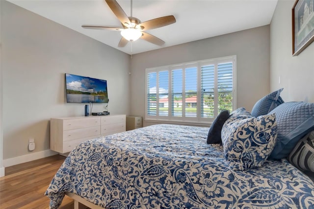 bedroom with baseboards, wood finished floors, and ceiling fan