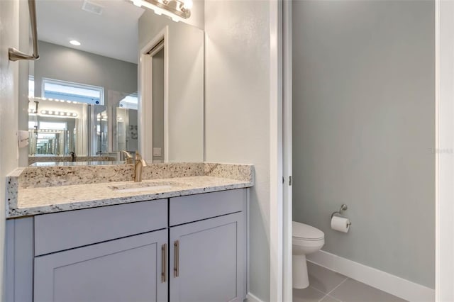 bathroom featuring toilet, vanity, tile patterned flooring, baseboards, and visible vents