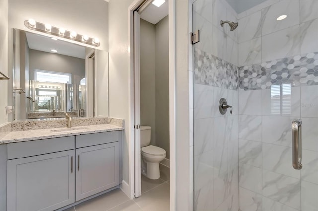 bathroom featuring a shower stall, toilet, tile patterned flooring, and vanity