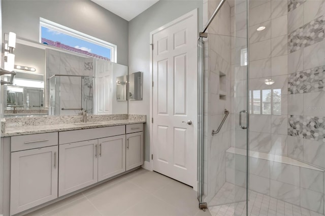 full bathroom featuring vanity, tile patterned floors, and a shower stall