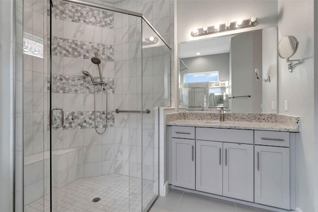 bathroom with tile patterned flooring, vanity, and a shower stall