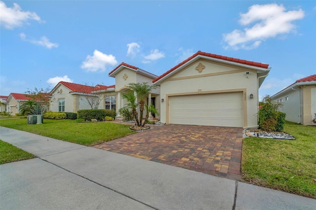 mediterranean / spanish house featuring a front yard, stucco siding, a tiled roof, decorative driveway, and a garage