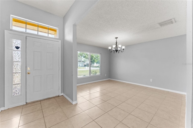 408 Magpie Ct, Kissimmee, FL 34759 - entryway featuring a chandelier, light tile patterned floors, and a textured ceiling