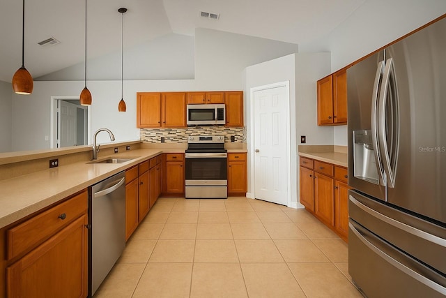 408 Magpie Ct, Kissimmee, FL 34759 - kitchen featuring stainless steel appliances, lofted ceiling, brown cabinets, and light countertops
