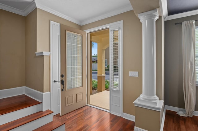 foyer featuring baseboards, crown molding, wood finished floors, and ornate columns