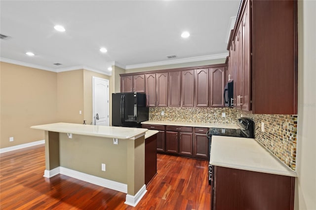 kitchen featuring crown molding, black appliances, decorative backsplash, light countertops, and dark wood-type flooring