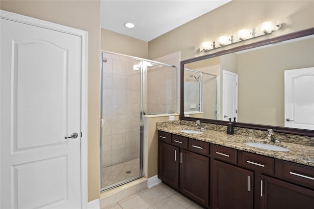 full bathroom featuring a shower stall, tile patterned flooring, and a sink