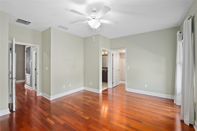 unfurnished bedroom featuring baseboards, wood finished floors, and visible vents