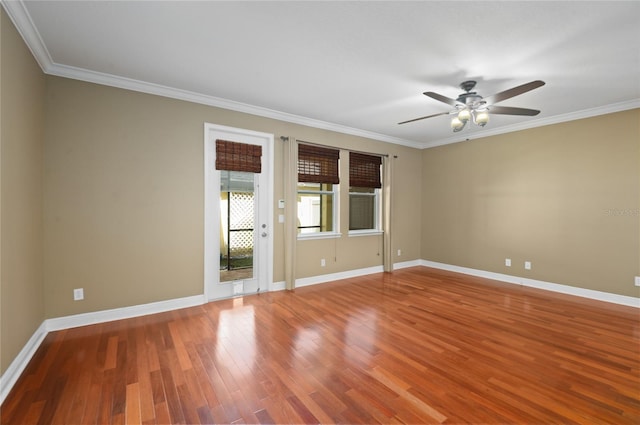 empty room with crown molding, baseboards, a ceiling fan, and wood finished floors