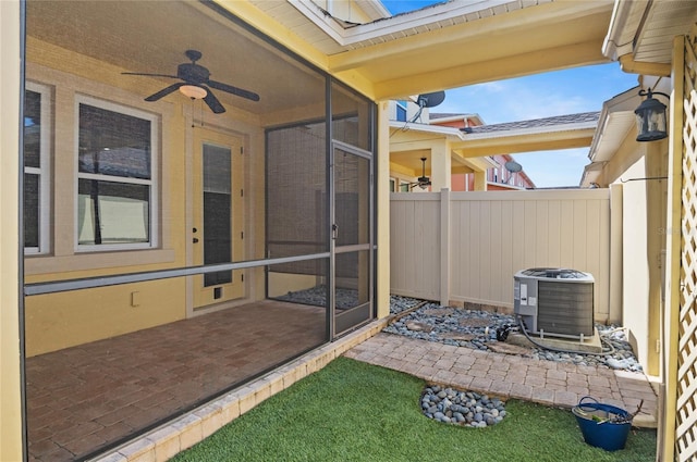 view of patio featuring central air condition unit, fence, a sunroom, and ceiling fan
