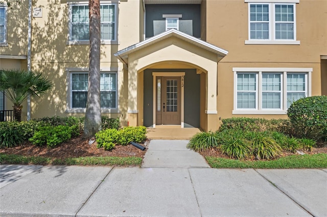 property entrance with stucco siding