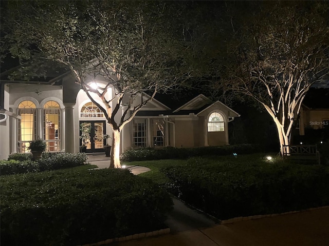 view of front facade with french doors and stucco siding