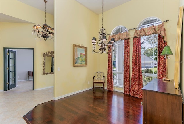 dining area featuring a chandelier, wood finished floors, and a towering ceiling