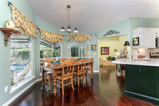 dining space with dark wood-style flooring, a notable chandelier, and baseboards