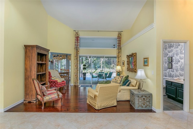 living area with high vaulted ceiling and baseboards
