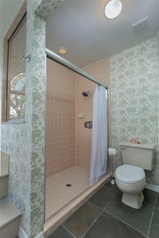 full bathroom featuring visible vents, toilet, a stall shower, wallpapered walls, and tile patterned floors