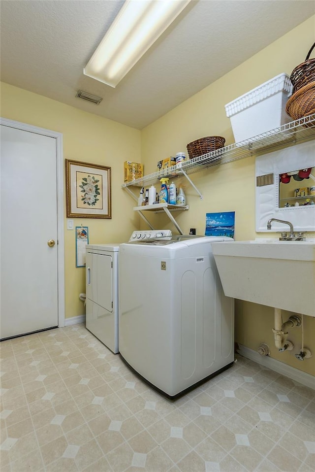 laundry area featuring visible vents, laundry area, baseboards, and separate washer and dryer