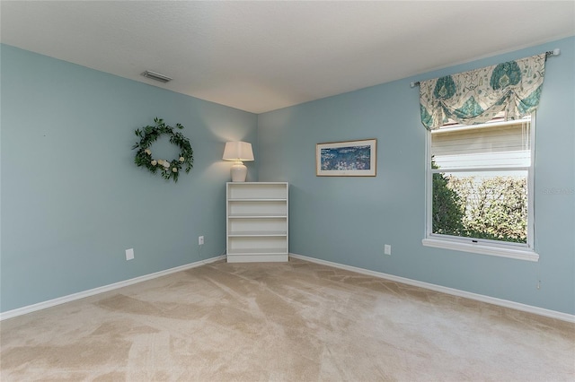 unfurnished room with visible vents, baseboards, and light carpet
