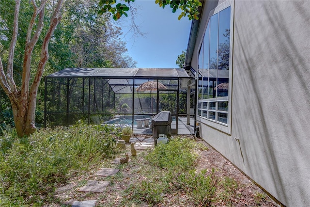 view of yard with a swimming pool and glass enclosure