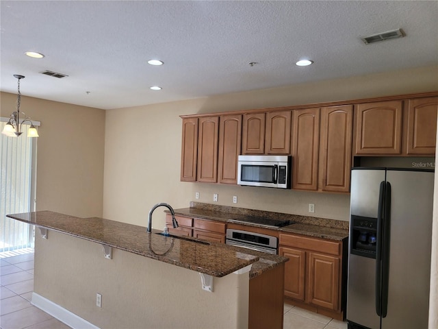 kitchen featuring stainless steel appliances, light tile patterned floors, a sink, a kitchen bar, and recessed lighting