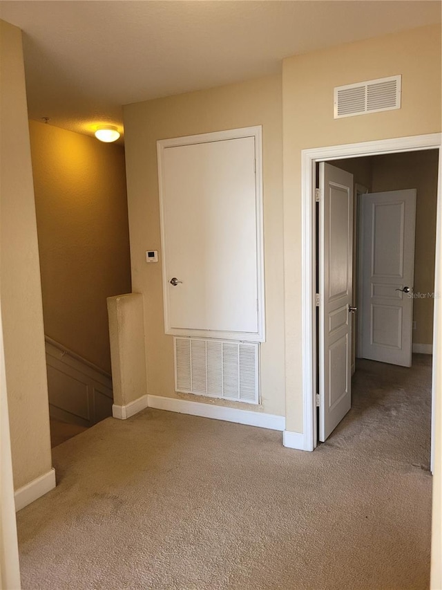 spare room featuring carpet floors and baseboards
