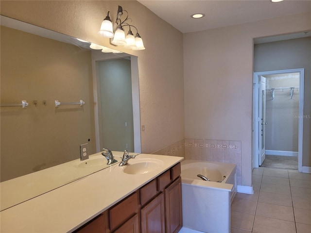 bathroom with tile patterned flooring, a garden tub, vanity, a walk in closet, and recessed lighting