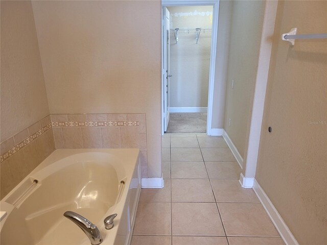 bathroom with tile patterned floors and a bath