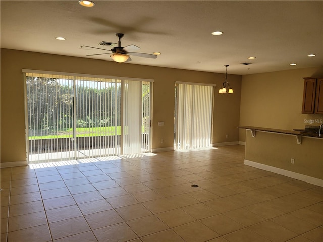 unfurnished living room with recessed lighting, baseboards, ceiling fan, light tile patterned flooring, and a chandelier