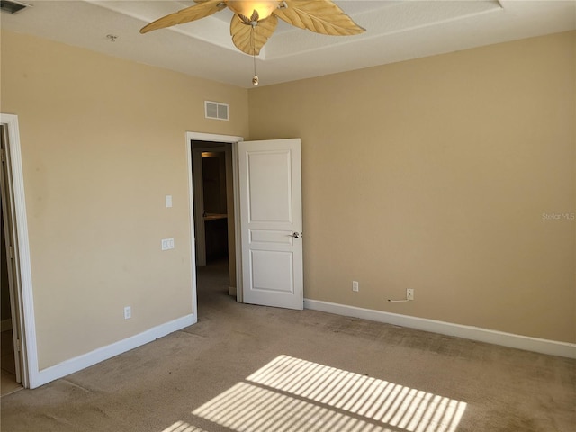 unfurnished bedroom featuring light colored carpet, baseboards, and ceiling fan