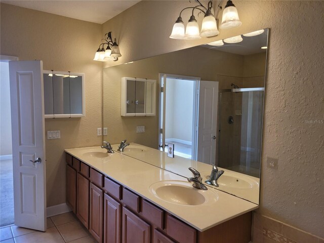 full bath with a stall shower, a textured wall, tile patterned floors, and double vanity