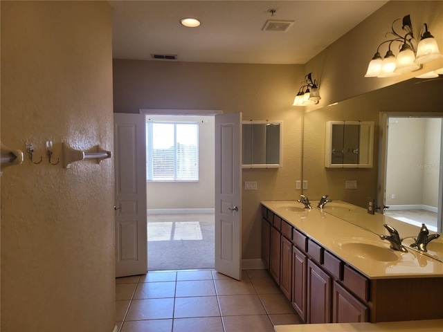 bathroom featuring baseboards, tile patterned flooring, double vanity, and recessed lighting