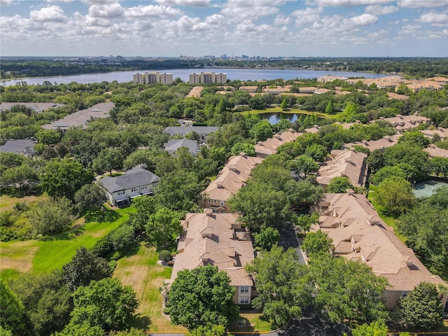 aerial view of residential area with a large body of water and a tree filled landscape